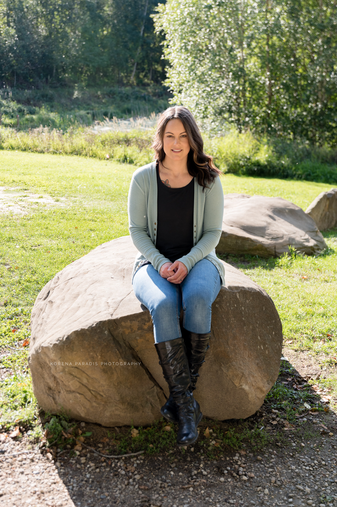 A photo of Amy Quintal sitting on a large rock