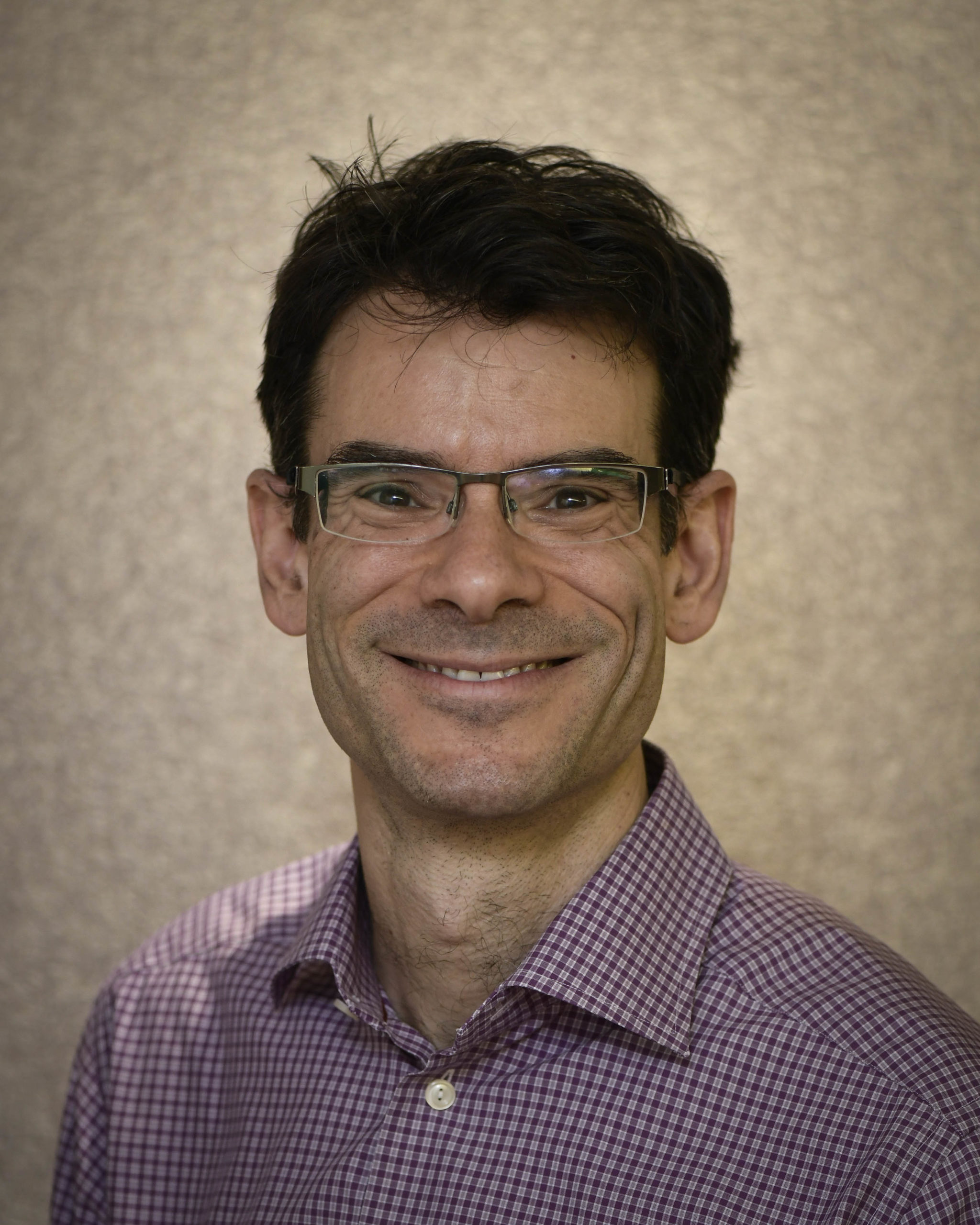 Dr. Lonnie Zwaigenbaum, chair of the Autism Diagnosis Community of Practice. Wearing glasses and a purple button down shirt